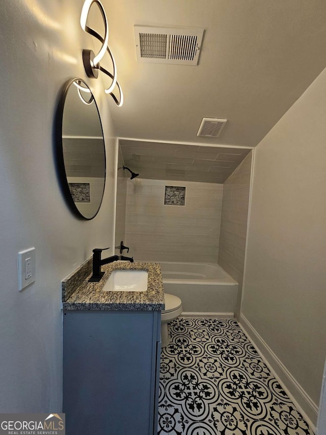 full bathroom with tile patterned flooring, vanity, tiled shower / bath combo, and toilet