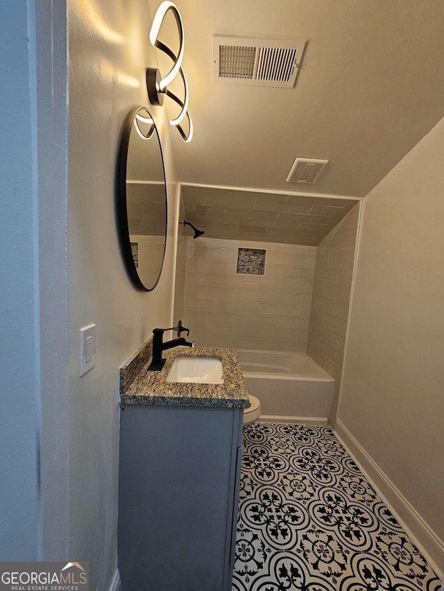 full bathroom featuring vanity, tiled shower / bath, tile patterned floors, and toilet