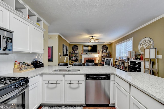 kitchen with sink, white cabinets, light stone counters, kitchen peninsula, and stainless steel appliances