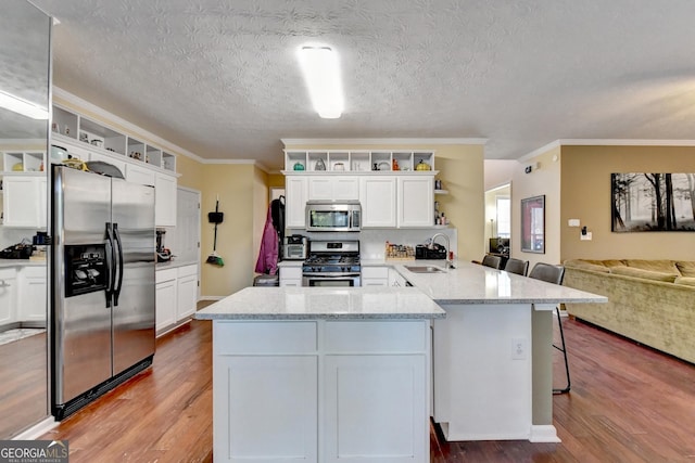 kitchen featuring appliances with stainless steel finishes, sink, a breakfast bar area, and white cabinets