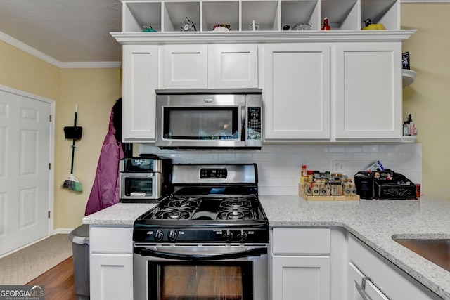 kitchen featuring light stone counters, tasteful backsplash, ornamental molding, appliances with stainless steel finishes, and white cabinets