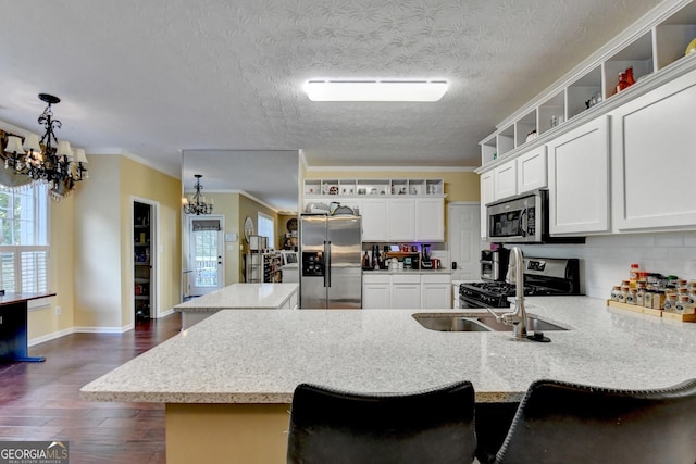 kitchen featuring stainless steel appliances, white cabinetry, a breakfast bar, and a chandelier