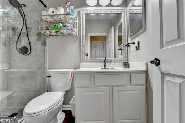 bathroom with vanity, a tile shower, and toilet