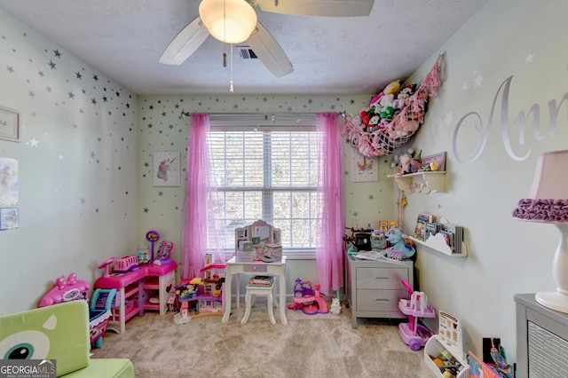 playroom with ceiling fan, light carpet, and a textured ceiling