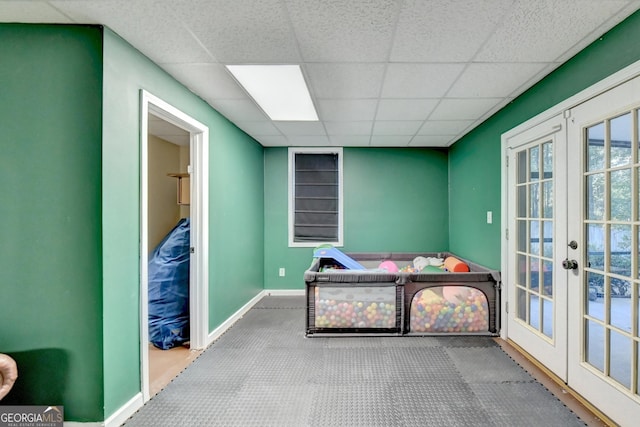 bedroom featuring a drop ceiling and french doors