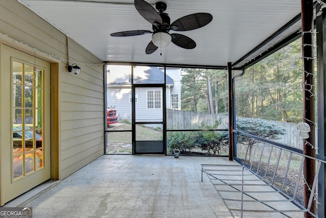 unfurnished sunroom featuring ceiling fan and plenty of natural light