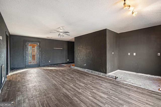 unfurnished living room with dark hardwood / wood-style flooring, a textured ceiling, and ceiling fan