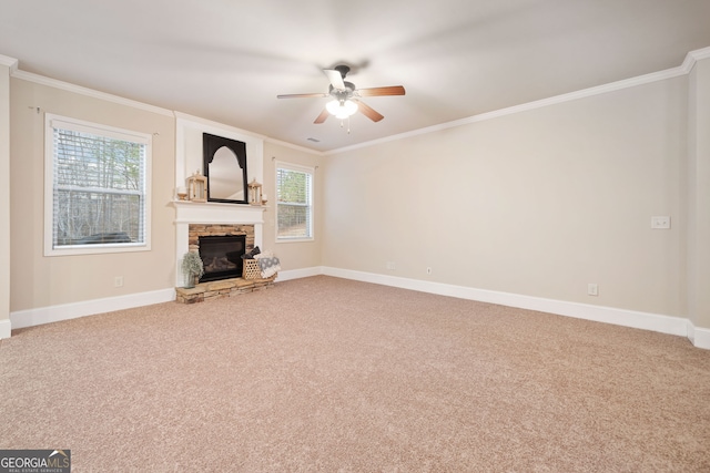 unfurnished living room featuring ornamental molding, carpet floors, ceiling fan, and a fireplace