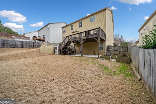 rear view of house featuring a wooden deck and a patio area