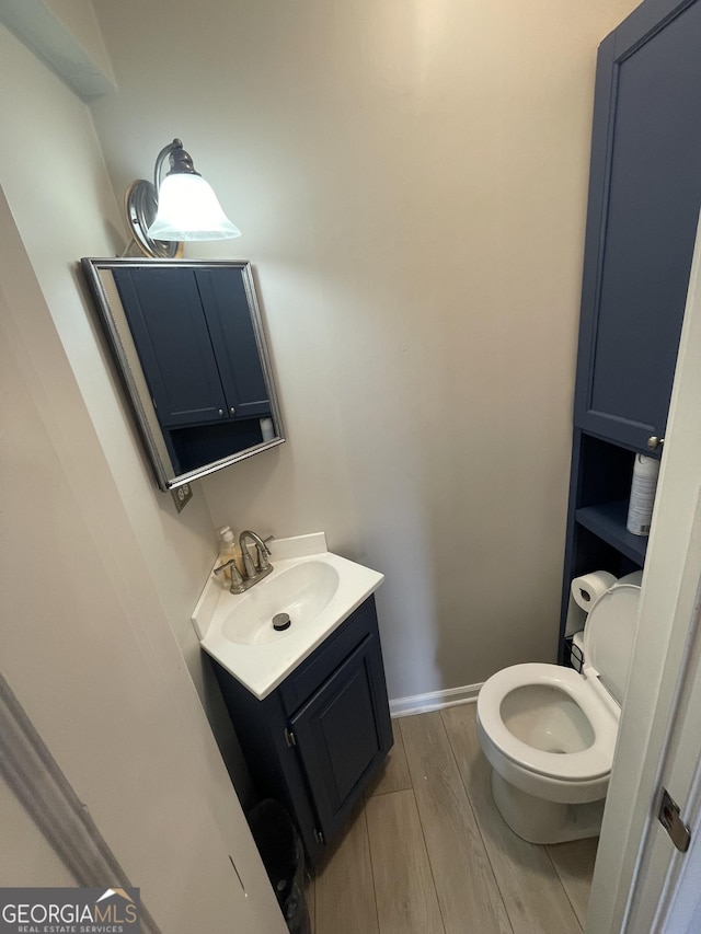 bathroom featuring hardwood / wood-style flooring, vanity, and toilet