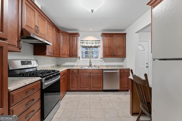 kitchen featuring light stone counters, stainless steel appliances, sink, and light tile patterned floors