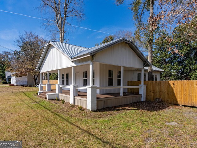 424 NW Central Ave, Blackshear, GA 31516 - rear view of house featuring a lawn, fence, covered porch, and metal roof