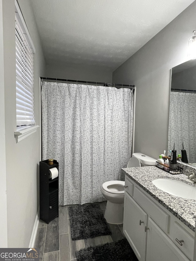 bathroom with vanity, a textured ceiling, and toilet