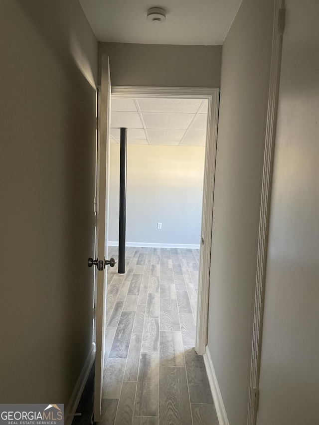 corridor featuring light hardwood / wood-style flooring and a paneled ceiling