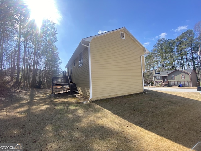 view of property exterior with a wooden deck and a yard