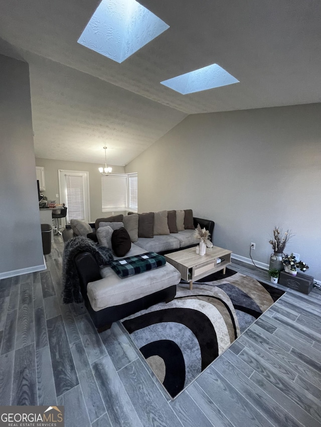 living room with an inviting chandelier, dark hardwood / wood-style floors, and lofted ceiling with skylight