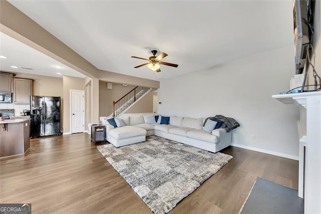 living room with ceiling fan and dark hardwood / wood-style flooring