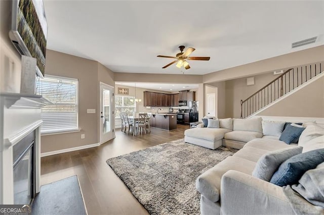 living room featuring dark hardwood / wood-style floors and ceiling fan