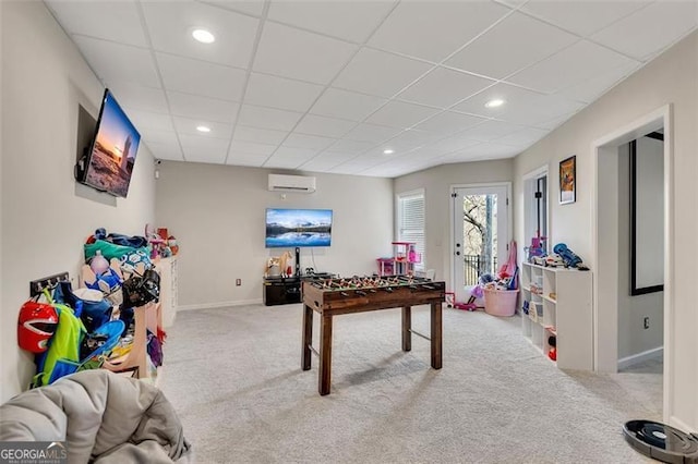 playroom featuring light carpet, a paneled ceiling, and a wall mounted AC