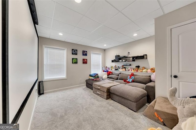 living room featuring a paneled ceiling and light colored carpet