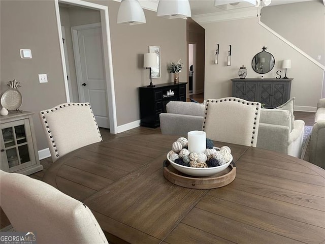 dining space featuring crown molding and dark wood-type flooring