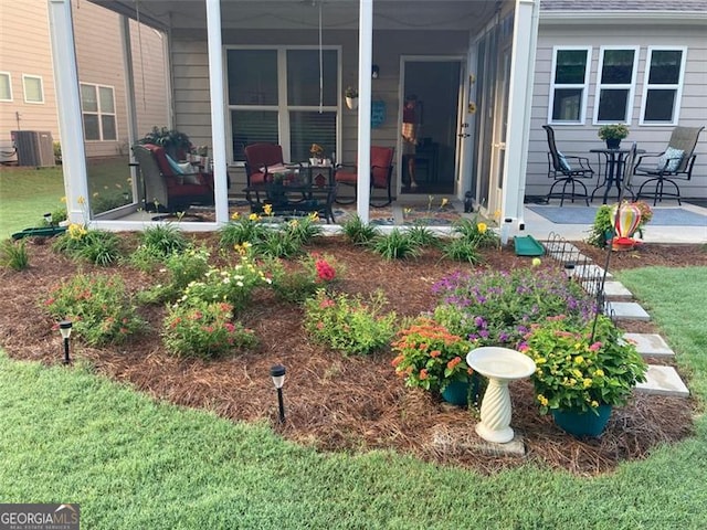 view of yard with a sunroom, central air condition unit, and a patio area