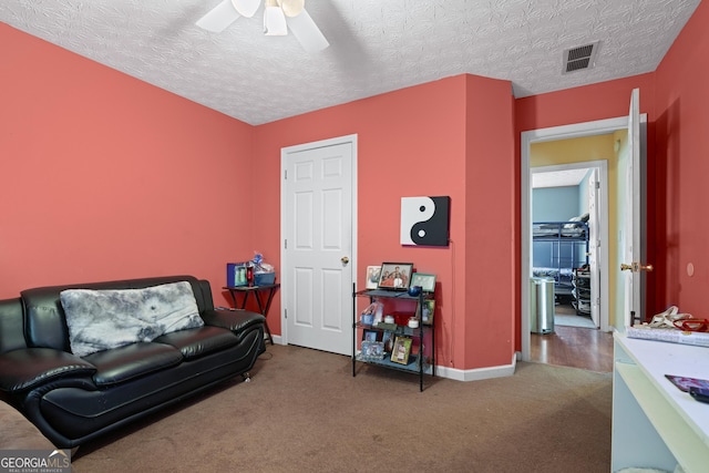 sitting room featuring carpet flooring, a textured ceiling, and ceiling fan