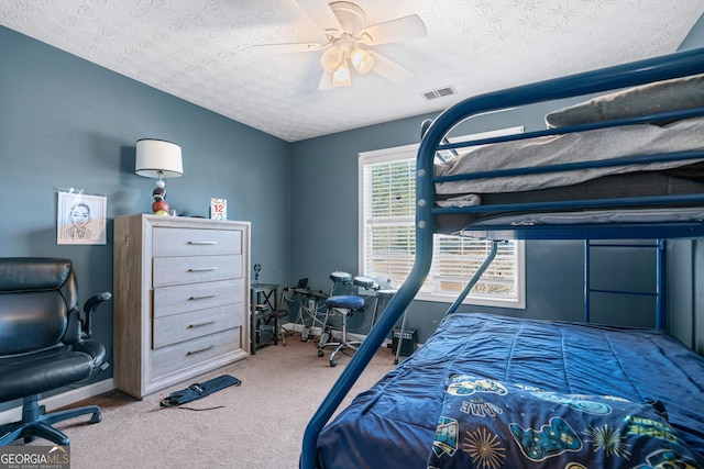 bedroom featuring ceiling fan, a textured ceiling, and carpet