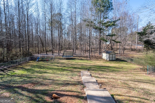 view of yard with a trampoline and a shed