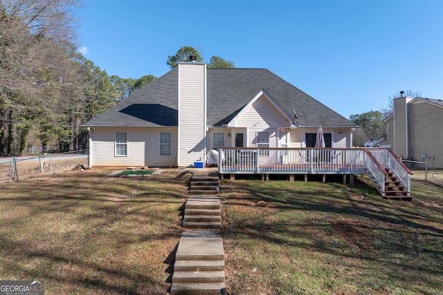 rear view of house with a wooden deck and a yard