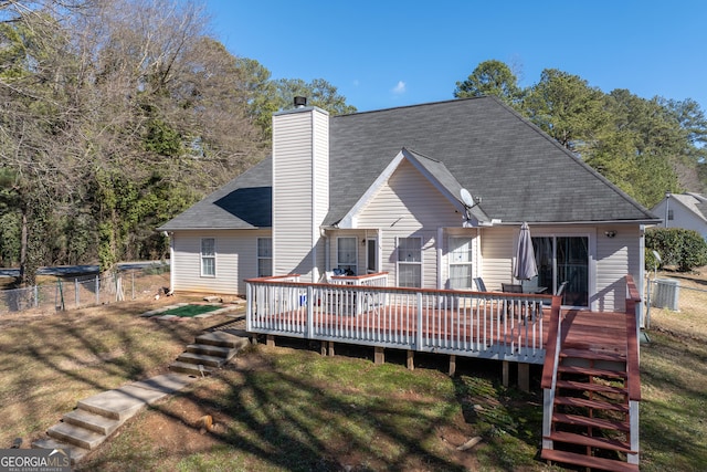 rear view of house with a yard and a deck