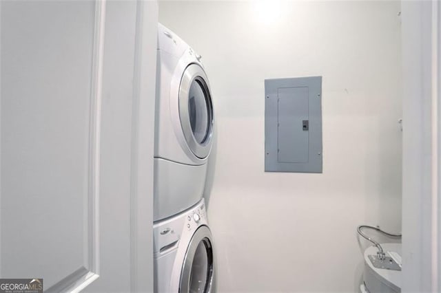 washroom with stacked washer / drying machine and electric panel