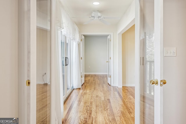 hallway with light hardwood / wood-style flooring and french doors