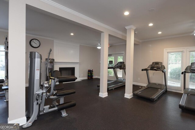 exercise room with crown molding, ceiling fan, and decorative columns