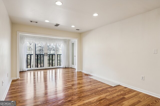 spare room with wood-type flooring and french doors