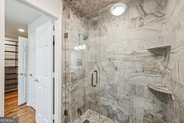 bathroom featuring wood-type flooring and a shower with shower door