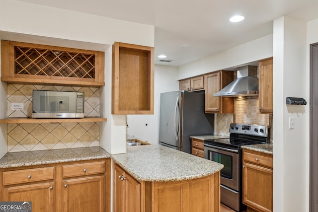 kitchen featuring appliances with stainless steel finishes, tasteful backsplash, sink, light stone countertops, and wall chimney range hood