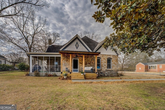 view of front of home featuring a front lawn and a sunroom