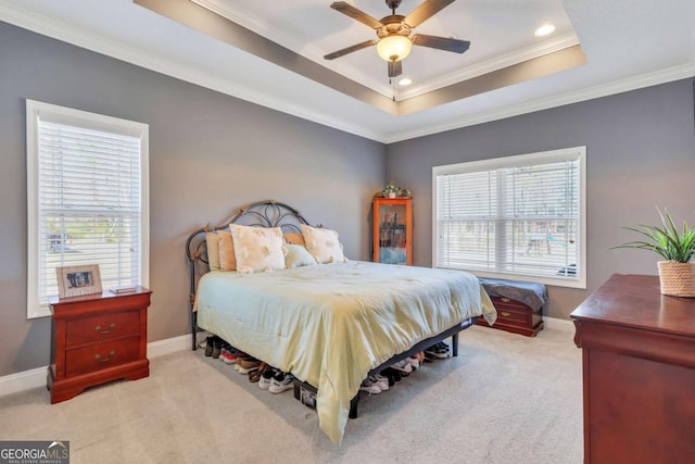 bedroom featuring a raised ceiling, ornamental molding, light carpet, and multiple windows