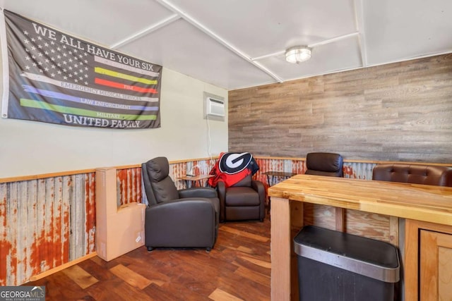 living room with dark hardwood / wood-style floors, a wall mounted air conditioner, and wooden walls