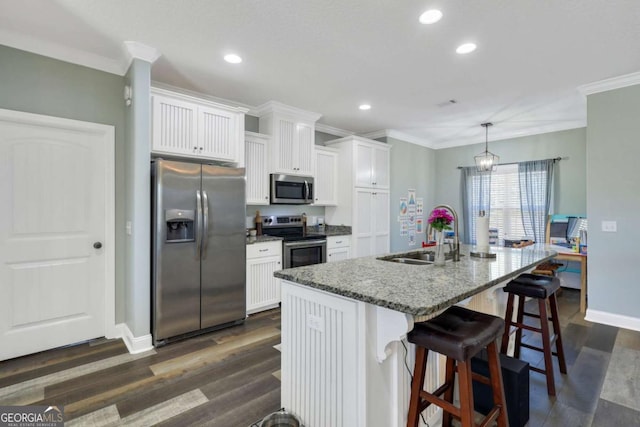 kitchen featuring sink, a breakfast bar area, stainless steel appliances, white cabinets, and a center island with sink