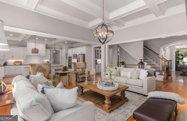 living room featuring an inviting chandelier, coffered ceiling, light hardwood / wood-style floors, and beam ceiling