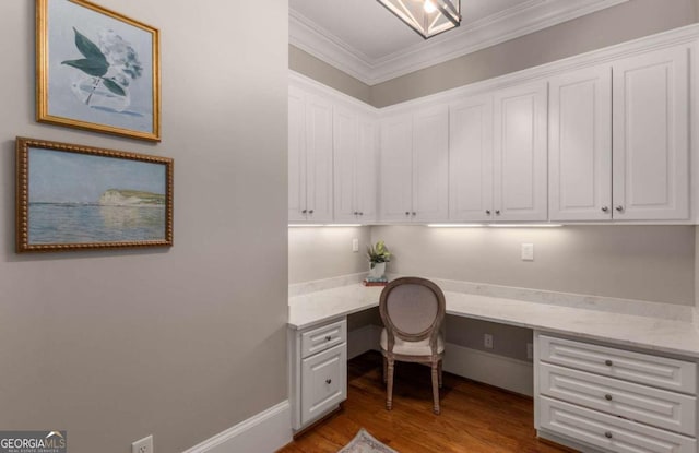 office with crown molding, hardwood / wood-style flooring, and built in desk