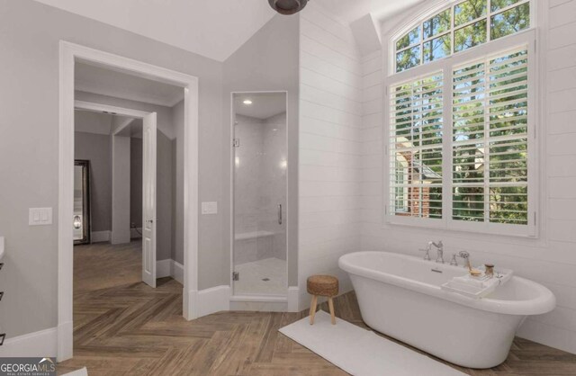 bathroom featuring parquet flooring, lofted ceiling, and separate shower and tub