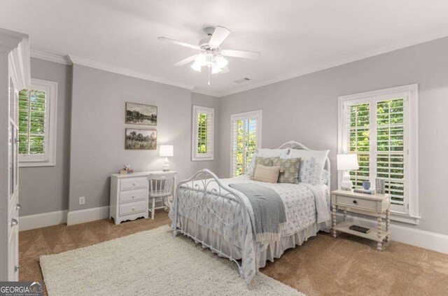 bedroom featuring multiple windows, crown molding, and light carpet