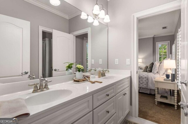 bathroom with crown molding, vanity, and an inviting chandelier