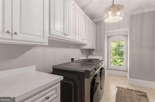 laundry area featuring sink, light tile patterned floors, cabinets, washer hookup, and a chandelier