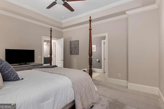 bedroom featuring light carpet, ensuite bath, ornamental molding, and ceiling fan