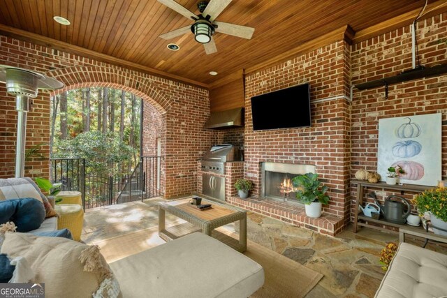 view of patio featuring an outdoor brick fireplace, an outdoor kitchen, and ceiling fan