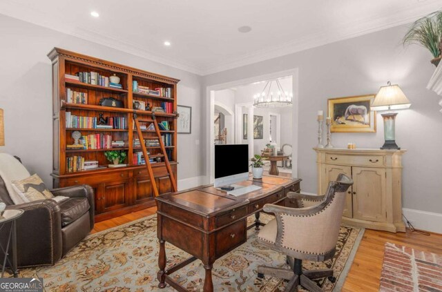 office space featuring crown molding, a chandelier, and light hardwood / wood-style floors